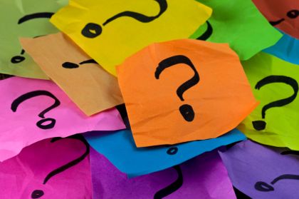 questions, decision making or uncertainty concept - a pile of colorful crumpled sticky notes with question marks